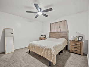 Bedroom with light colored carpet and a ceiling fan