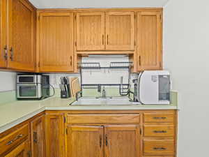 Kitchen featuring light countertops and wood finish cabinetry