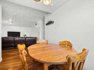 Dining space with wood finished floors and a textured ceiling