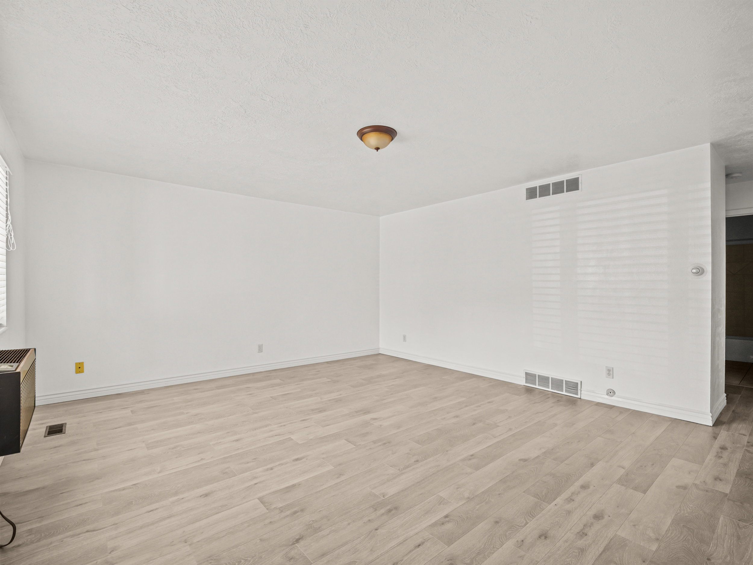 Unfurnished living room featuring light wood-style floors and a textured ceiling