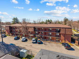 View of apartment building / complex featuring uncovered parking