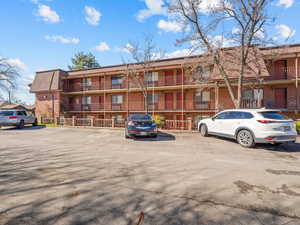 View of apartment building / complex with uncovered parking