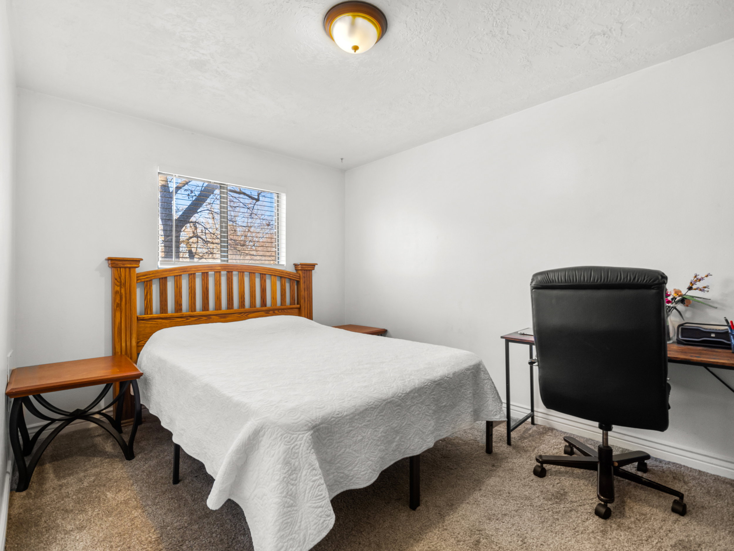 Carpeted bedroom with an office area and a textured ceiling