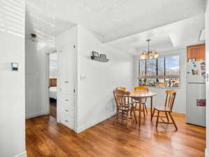 Dining room with light wood-style floors, a chandelier, and a tray ceiling
