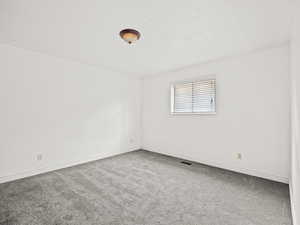 Carpeted spare room with baseboards