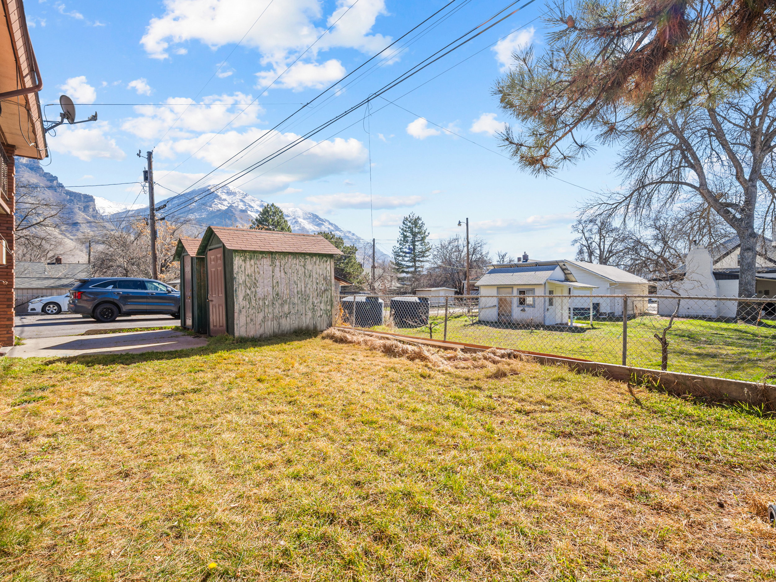 Fenced backyard featuring a storage unit