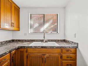 Kitchen with wood finish cabinets and dark countertops