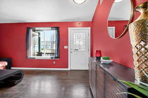 Foyer entrance featuring baseboards and dark wood-style floors