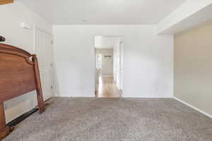 Unfurnished bedroom featuring light colored carpet and baseboards