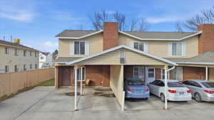 Traditional-style house featuring roof with shingles, brick siding, and a chimney