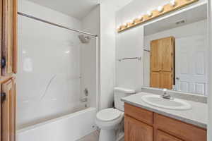 Bathroom featuring vanity, shower / bath combination, and light tile patterned floors