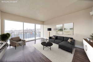 Living room featuring dark wood-style floors and a textured ceiling