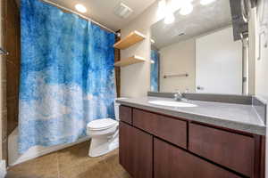 Bathroom featuring vanity, light tile patterned floors, and shower / bathtub combination with curtain
