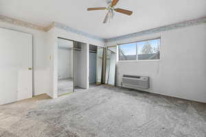 Unfurnished bedroom featuring carpet floors, two closets, and ceiling fan