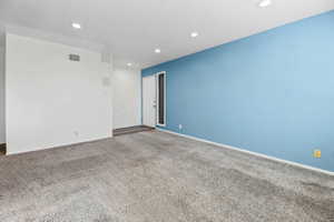 Unfurnished room with dark colored carpet and recessed lighting