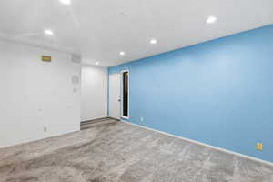 Carpeted spare room featuring baseboards and recessed lighting