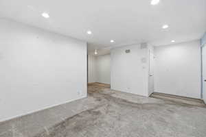 Carpeted spare room featuring recessed lighting and baseboards