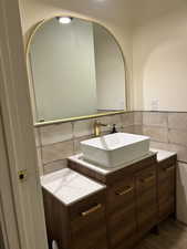 Bathroom with vanity and tile walls