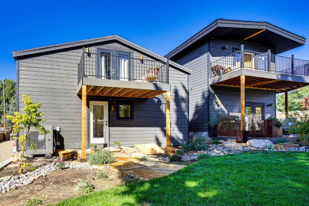 Rear view of house featuring a balcony, a yard, and a patio