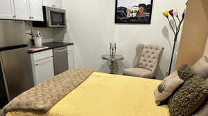 Kitchen featuring dark countertops, stainless steel appliances, and white cabinets