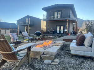 Rear view of property with french doors, a patio area, a fire pit, and a mountain view