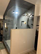 Bathroom featuring light wood finished floors and a shower stall