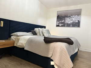 Bedroom featuring wood tiled floors and baseboards