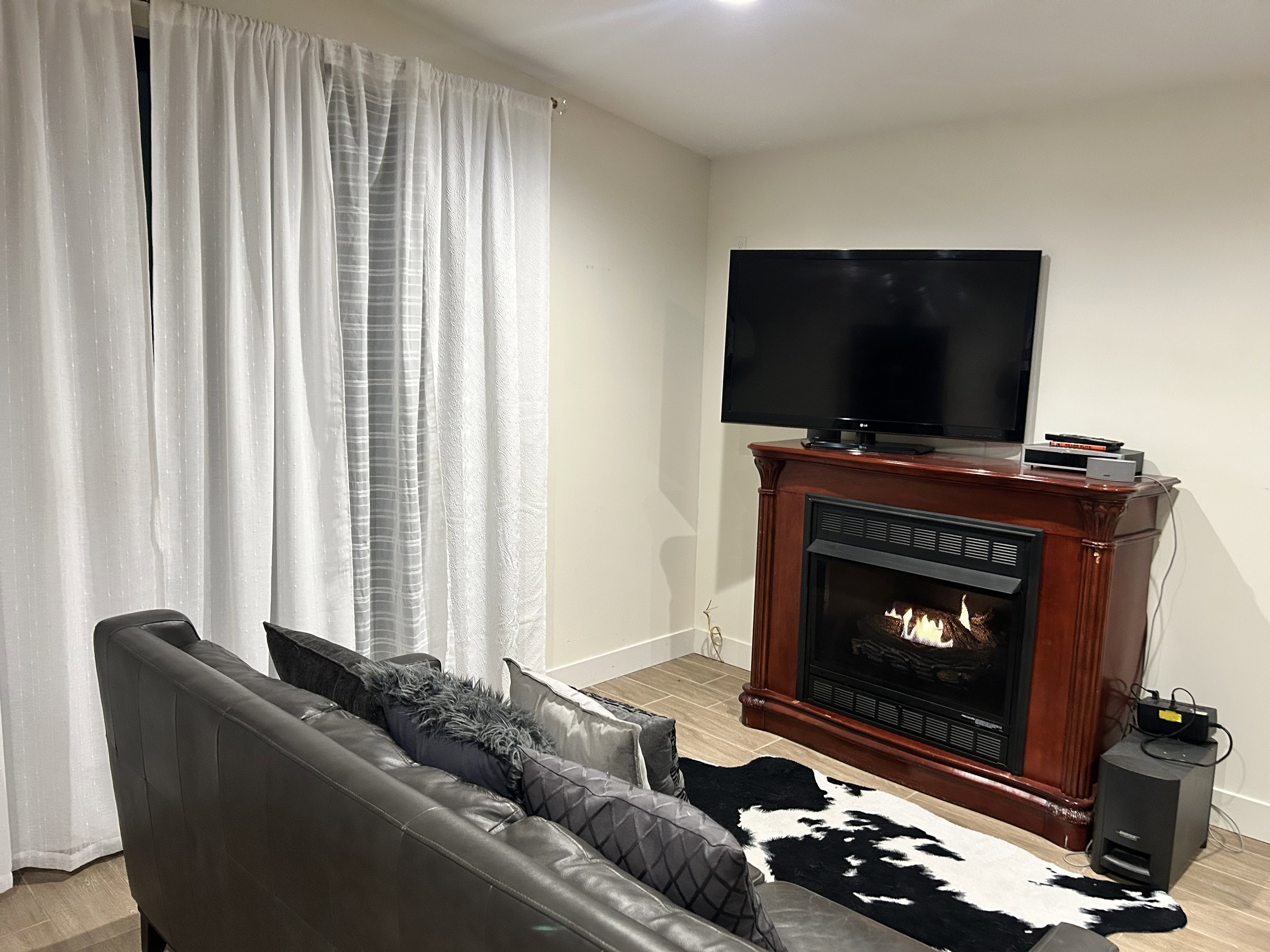 Living area featuring wood tiled floors and a lit fireplace