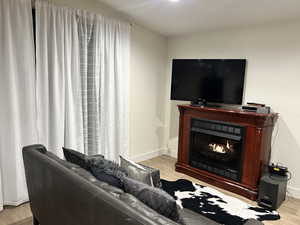 Living area featuring wood tiled floors and a lit fireplace