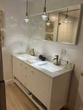 Bathroom featuring double vanity and light wood-style flooring
