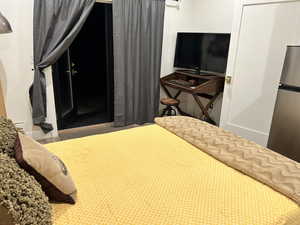 Bedroom with freestanding refrigerator