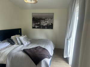 Bedroom with wood finish floors and baseboards