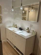 Full bathroom featuring double vanity and light wood-type flooring