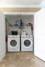 Laundry area with washer and dryer and crown molding