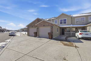 Traditional-style home with brick siding, concrete driveway, an attached garage, and stucco siding