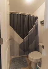 Bathroom with a shower with curtain and light tile patterned floors