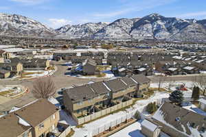 Snowy aerial view featuring a residential view and a mountain view