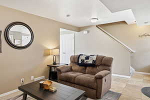 Living room featuring stairs and light tile patterned floors