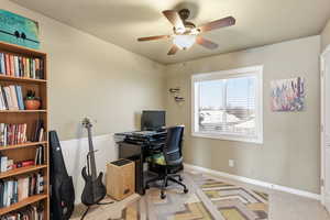 Office area featuring light colored carpet and ceiling fan