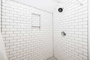 Bathroom with a tile shower and vaulted ceiling
