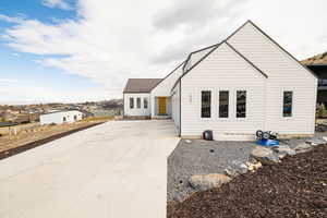 View of front of property with driveway, a metal roof, and a residential view