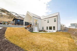Back of house with a patio area, a metal roof, and a balcony