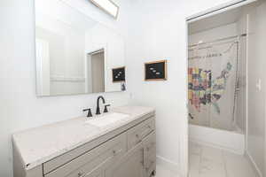 Bathroom featuring vanity and shower / tub combo with curtain