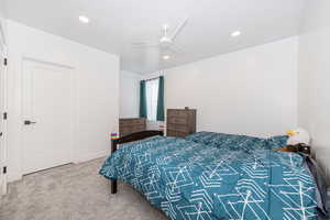 Bedroom with light carpet, ceiling fan, and recessed lighting