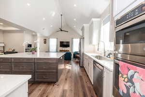 Dual tone kitchen featuring dual tone cabinetry, stainless steel appliances, open floor plan, dark wood-style flooring, and plenty of natural light
