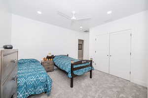 Bedroom featuring light carpet, ceiling fan, a closet, and recessed lighting