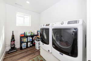 Laundry room with separate washer and dryer, dark wood-type flooring, and recessed lighting