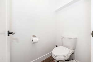 Bathroom with toilet and wood finished floors