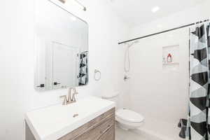Bathroom with vanity, a stall shower, and recessed lighting