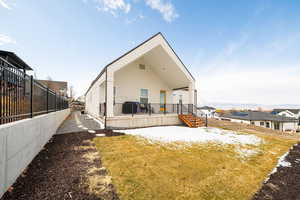 Snow covered back of property with a deck